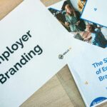 Flat lay of employer branding materials on an office table, showcasing marketing and design.