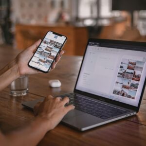 Woman edits social media content on phone and laptop at a cafe in Bali.