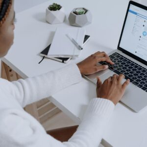 A woman engaging with social media on a laptop in a modern workspace.