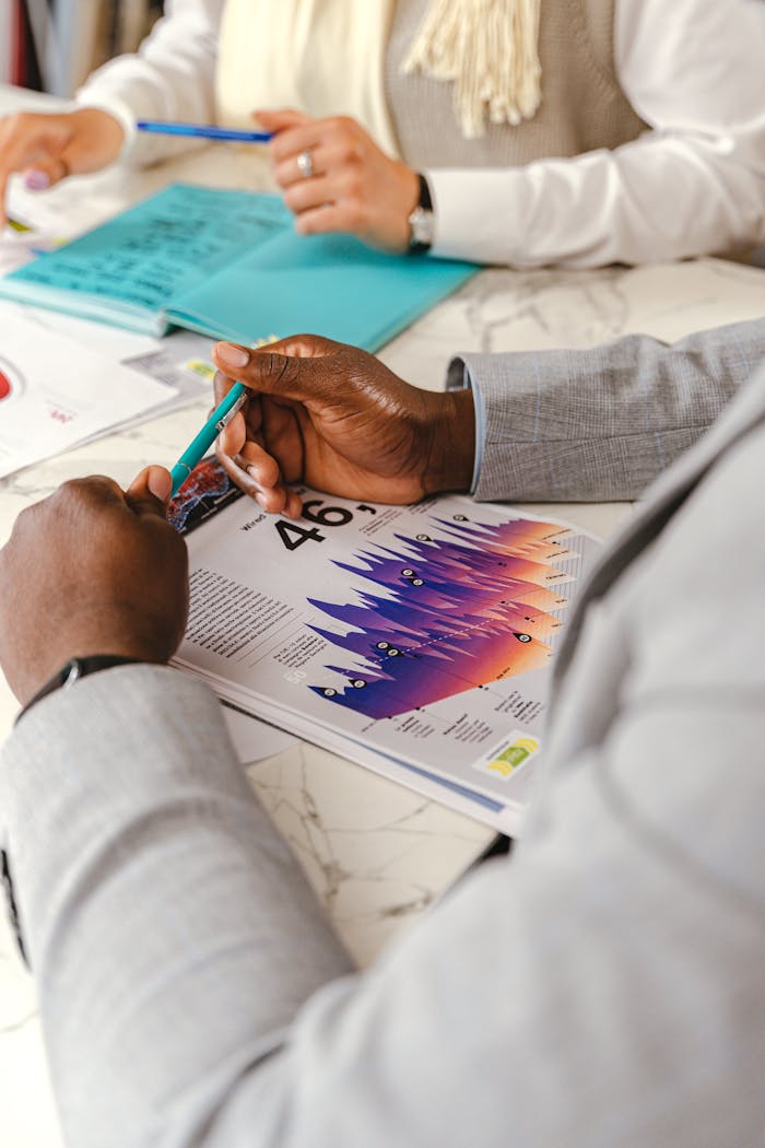 Individuals reviewing graphs during an in-depth business meeting, highlighting analysis.